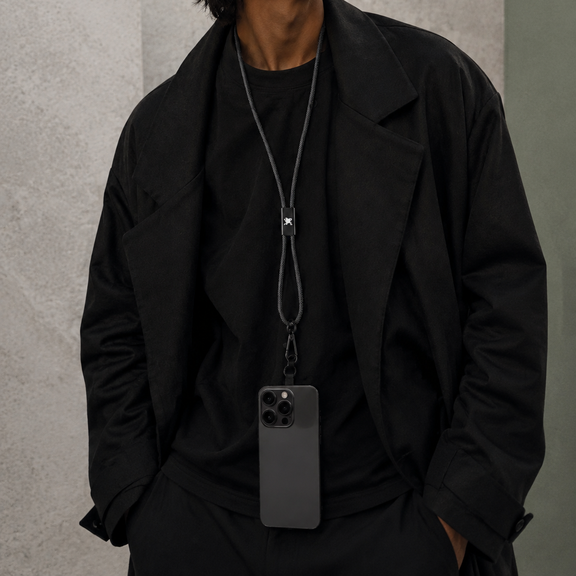 Littos Power Lanyard styled with a black outfit and smartphone